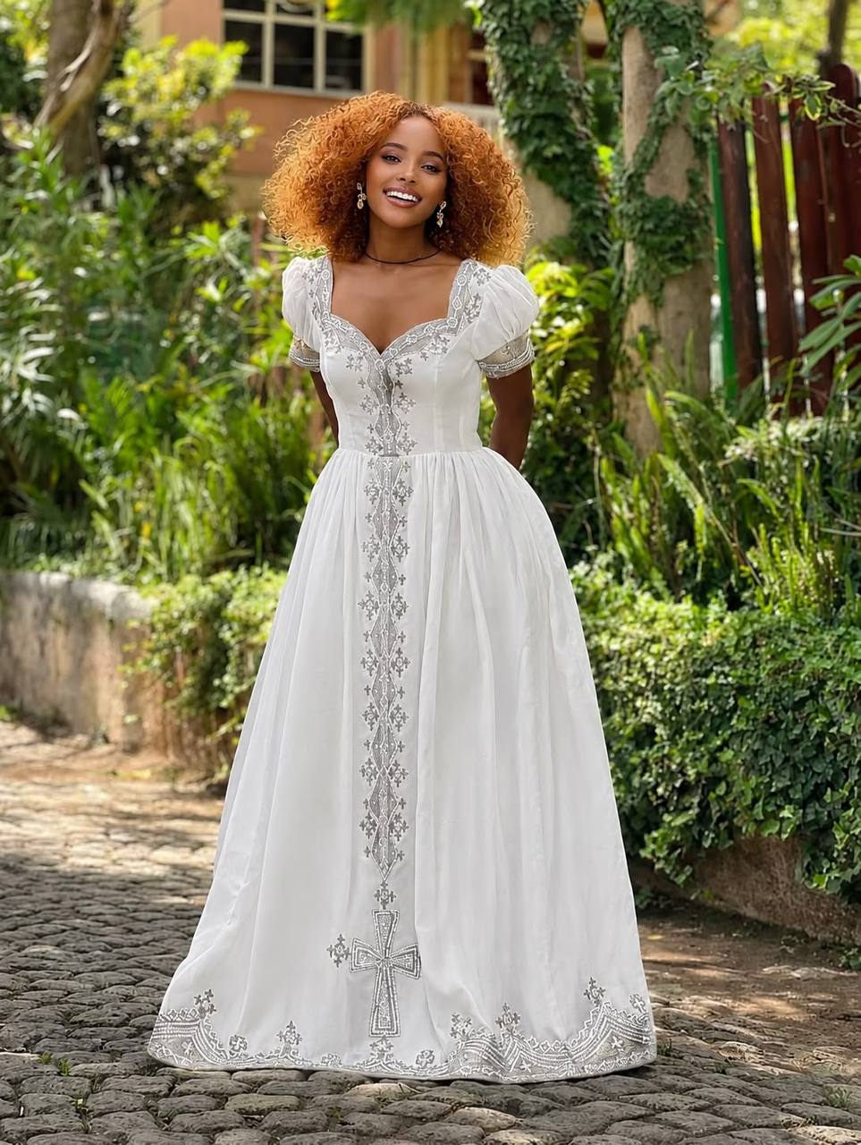Silver Cross Gown — White gown with puff sleeves and a full silver tibeb cross running the length of the skirt.