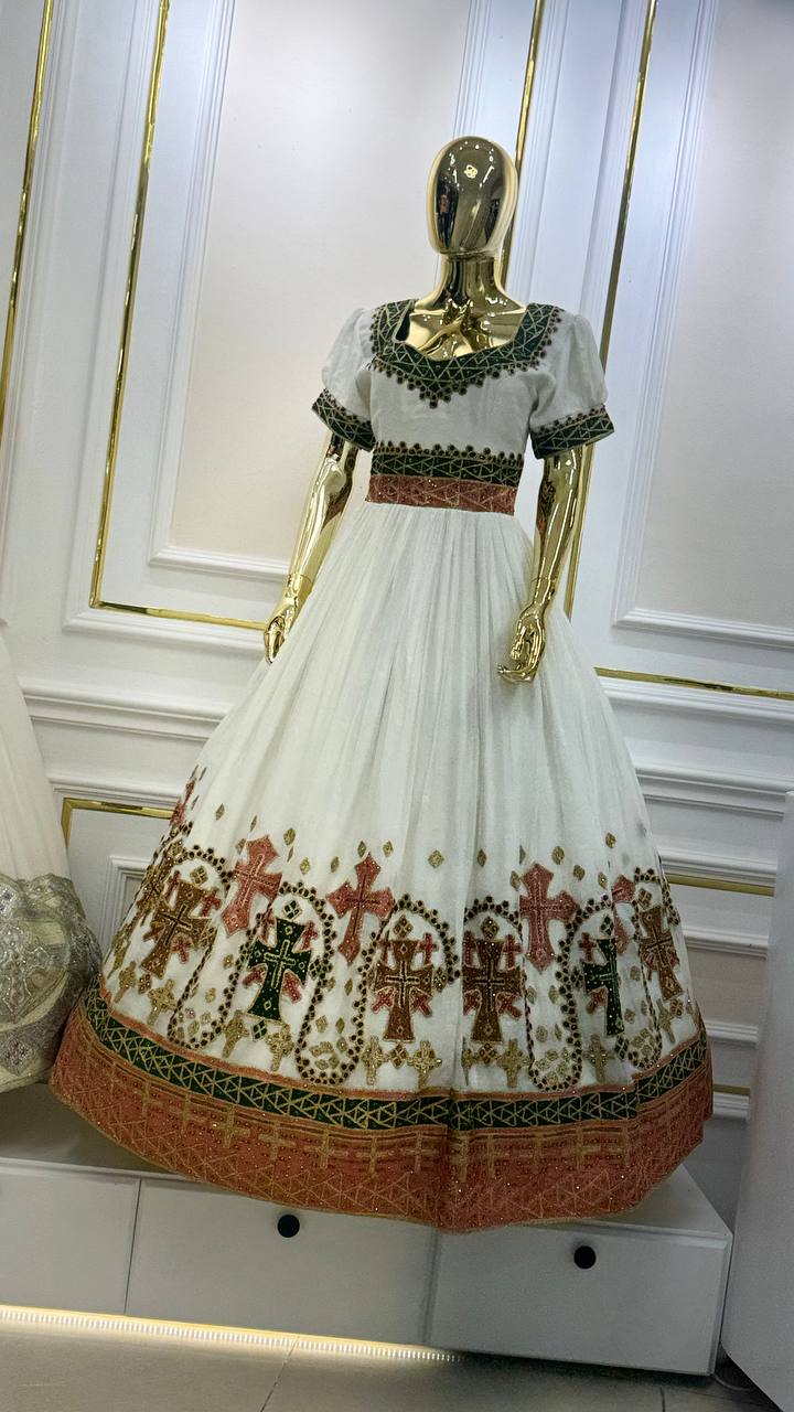 Crimson Cross Gown — White gown richly embroidered with green, crimson and gold crosses around the skirt and cuffs.